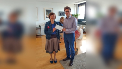 OB Florian Hartmann (re) gratulierte Brigitte Fiedler, der 1. Vorsitzenden des Dachauer Gästeführer e.V., mit einem finanziellen Zuschuss und würdigte damit das Engagement des rührigen Vereins. (Foto: Dachauer Gästeführer e. V.)