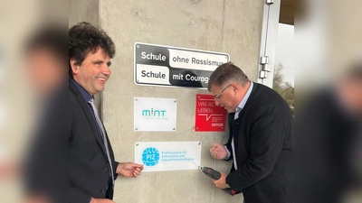 Landrat Stefan Löwl (rechts) und Christoph Strödecke, Schulleiter des Gymnasiums Markt Indersdorf, beim Anbringen der Auszeichnung „Profilschule für Informatik und Zukunftstechnologien“. (Foto: Landratsamt Dachau / Steffen Varga)