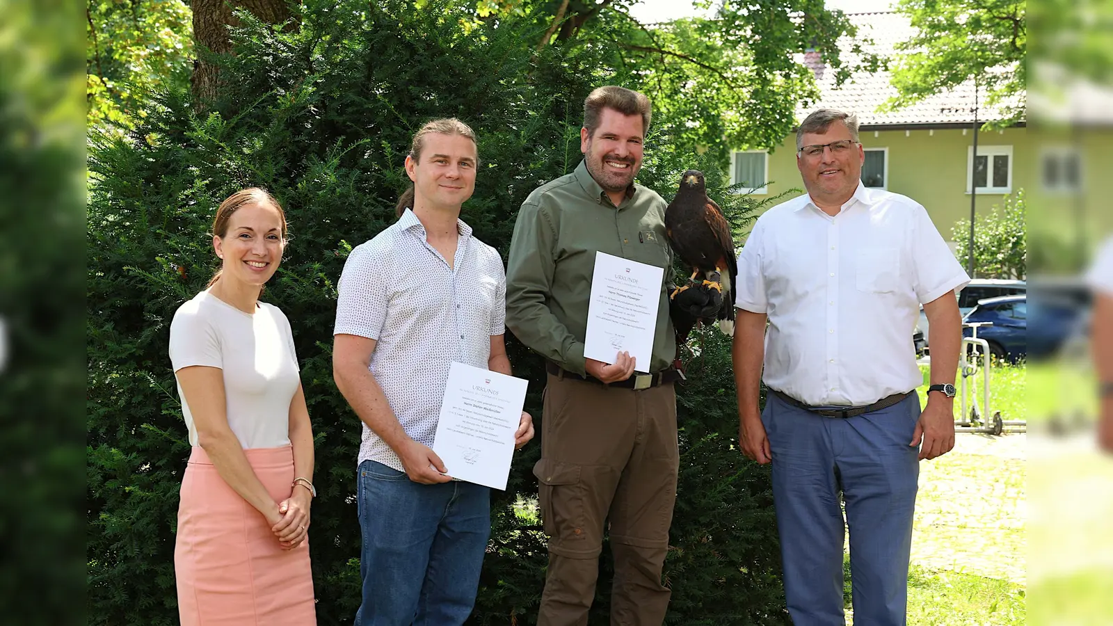 Die neuen Naturschutzwächter bei der Ernennung: v.l. Regierungsdirektorin Christina Düver, Abteilungsleiterin Umwelt, Stefan Weißmüller, Thomas Pilzweger mit Wüstenbussard Kihla und Landrat Stefan Löwl.  (Foto:  © Landratsamt Dachau, Veronika Plajer)