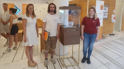 Lois Stinshoff hat diese Vitrine geschreinert. Sein Gesellenstück wurde mit einer Belobigung beim Innungswettbewerb „Die gute Form” ausgezeichnet. Anna Huber, Obermeisterin der Schreinerinnung, (rechts) und Sabrina Steinau von der Sparkasse Dachau (links) würdigten diese Leistung. (Foto: jj)